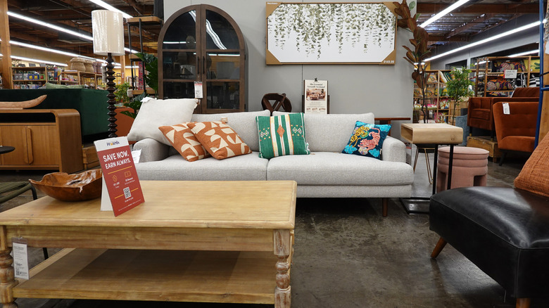 rustic coffee table in front of long neutral sofa