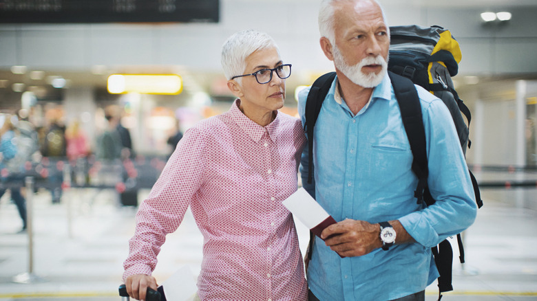 Serious mature couple standing in an airport