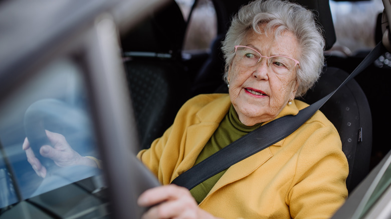 Focused older woman driver seated in a car