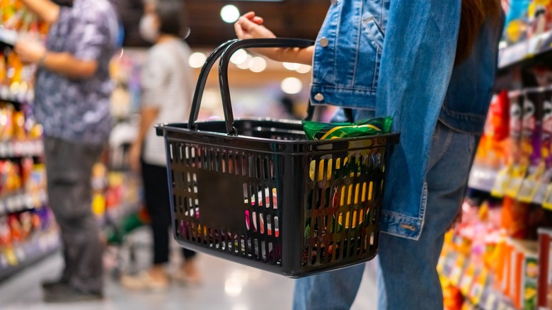 shopper holding a basket in store