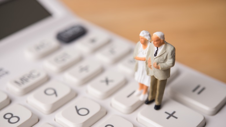 retired couple figurines on a calculator