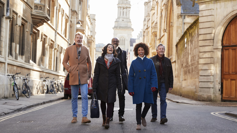 A diverse group of mature friends traveling through a picturesque European town