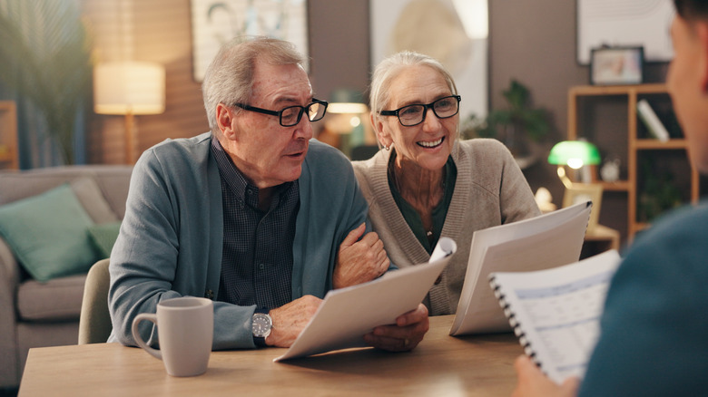 Senior couple looking at paperwork with someone