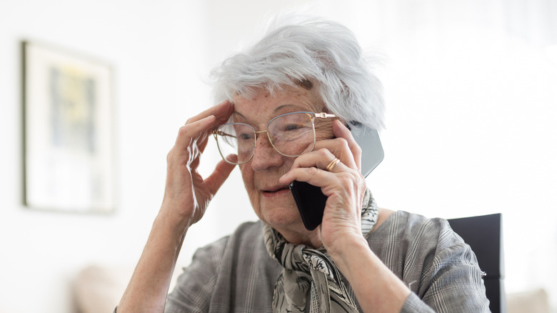 Confused elderly woman talking on the phone