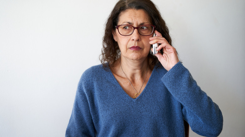Woman talking on a cell phone with a worried look on her face