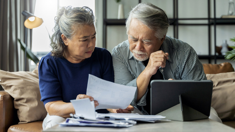 An older couple looking upset while going over their finances