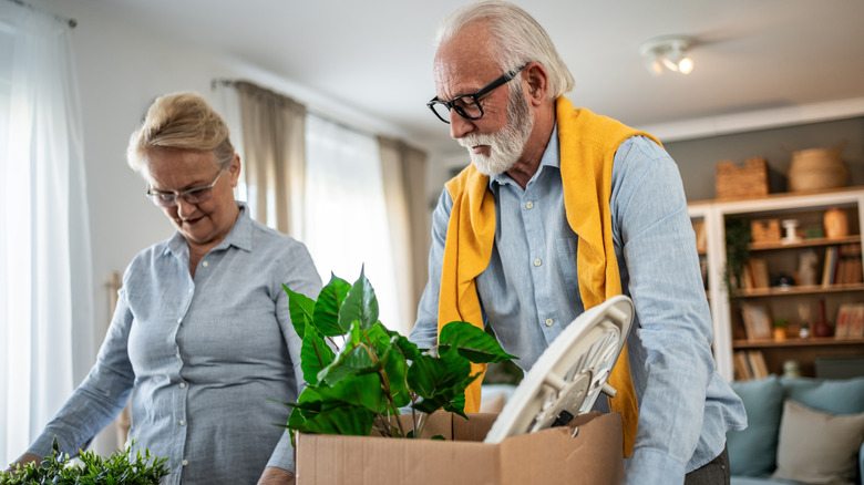 Older couple carrying boxes in their home