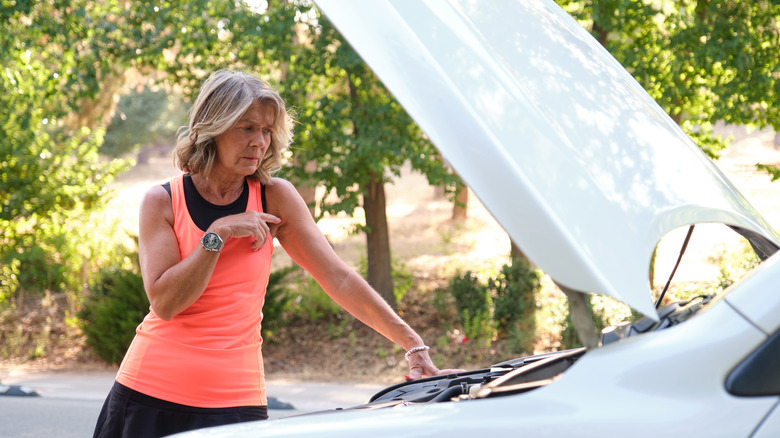 senior woman car hood open
