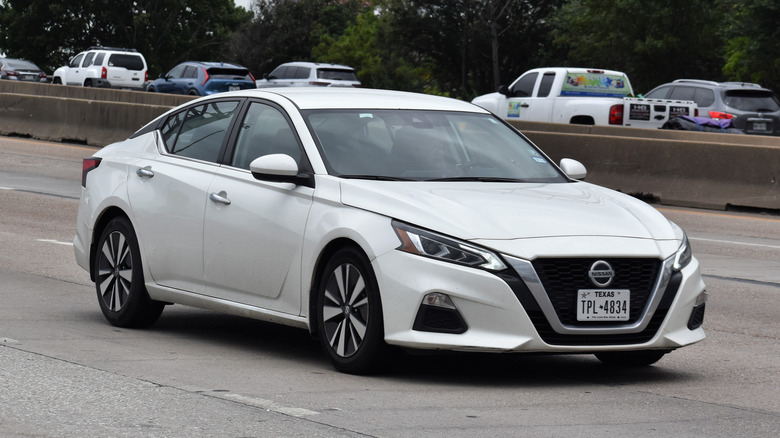 White Nissan Altima cruising
