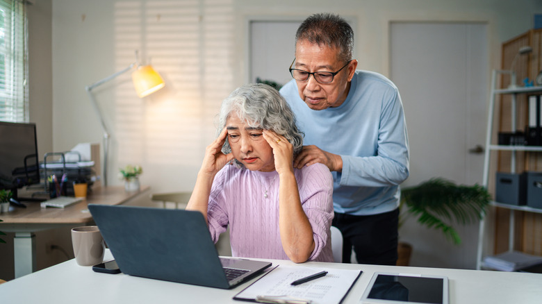 Upset retired couple looking at a laptop