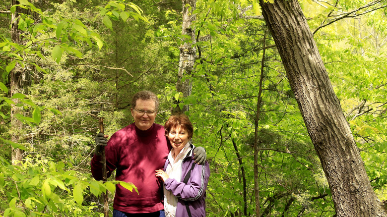 Older couple walking through forested area