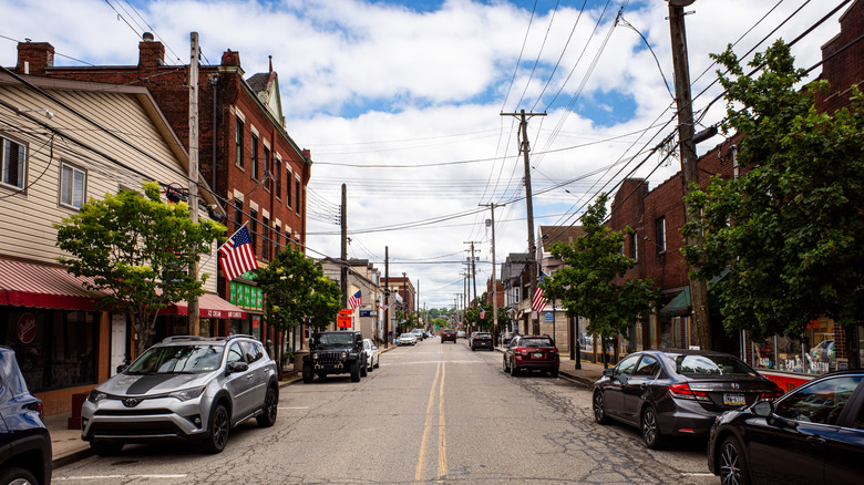 Street with cars, shops, and houses in Millvale