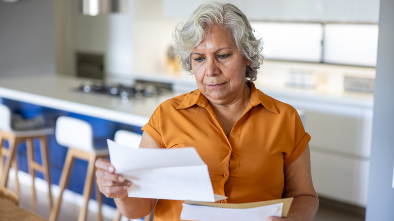 Elderly woman upset looking at a bill