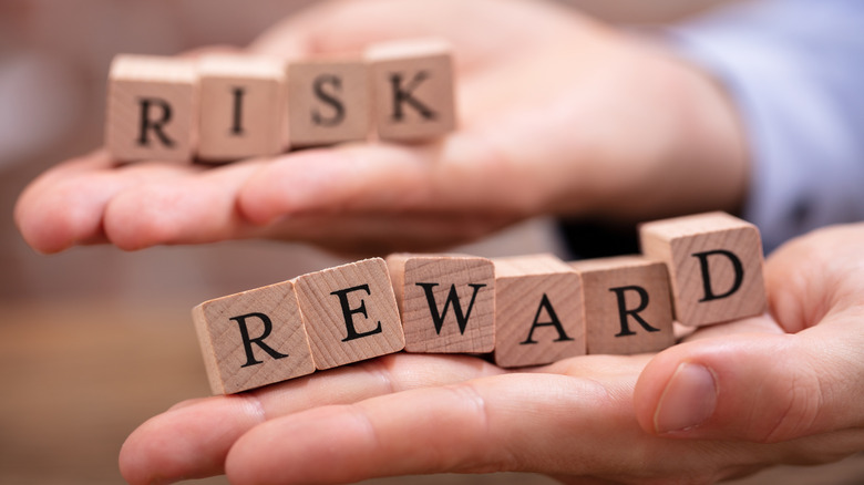 risk and reward spelled in blocks on hands