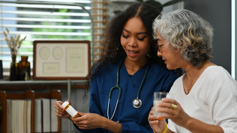 Doctor listening senior woman's breathing, heartbeats using a stethoscope.