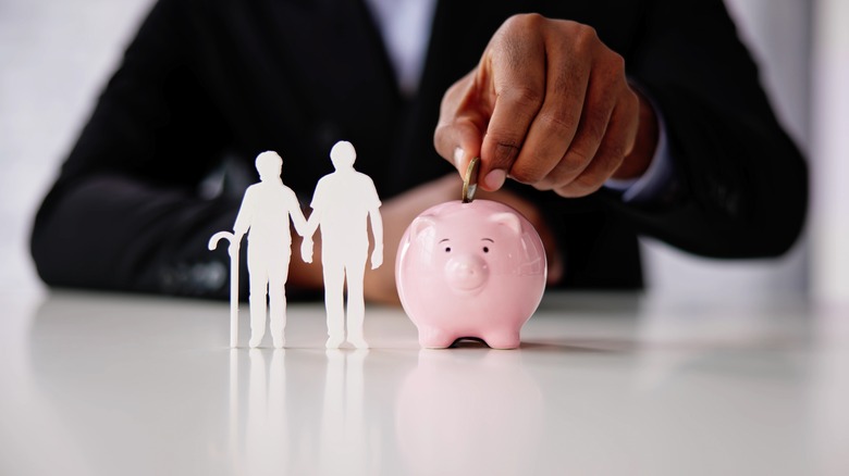 older American putting coin in piggy bank