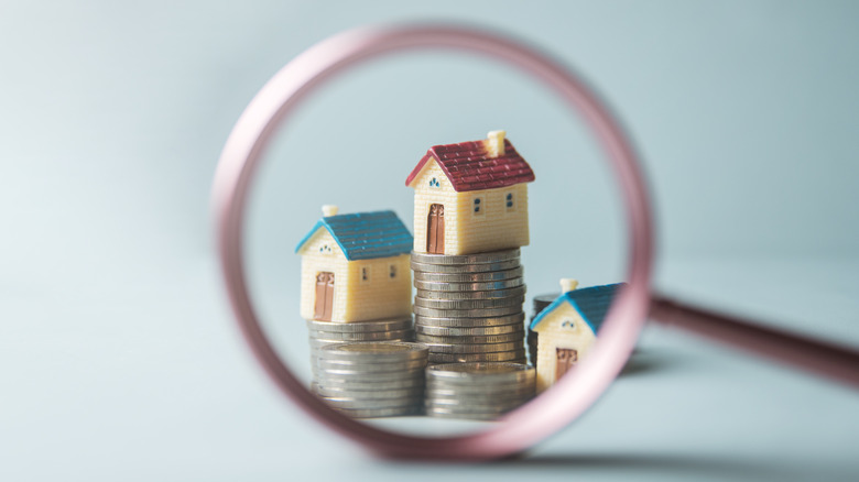 magnifying glass on house figurines