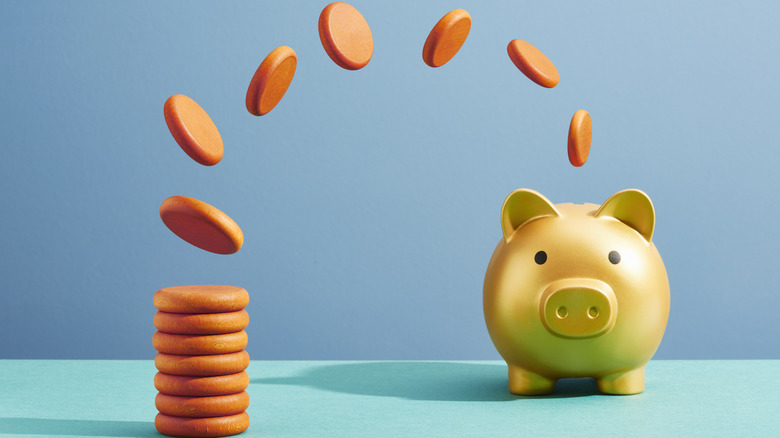 coins flipping into a gold piggy bank