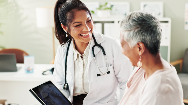 Mature woman, doctor, and tablet with radiograph
