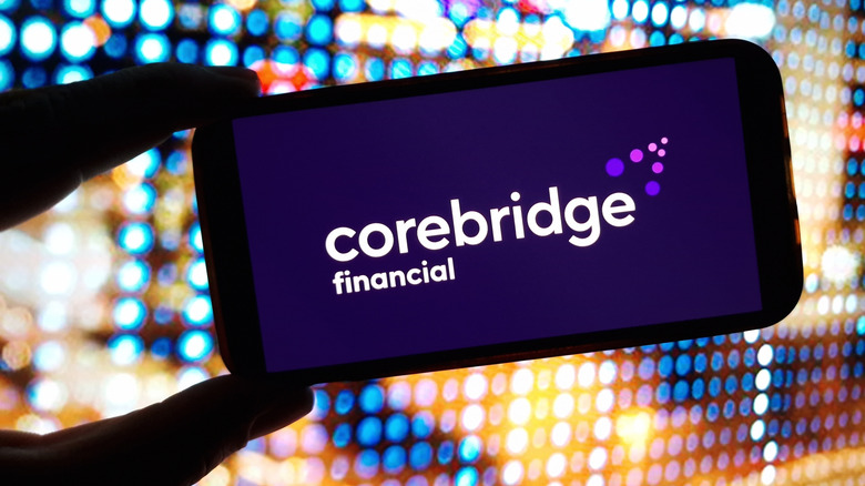 Close up of smartphone held between two fingers with Corebridge Financial app loading on screen