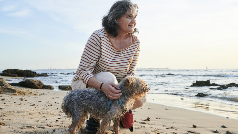 Older woman with dog at beach