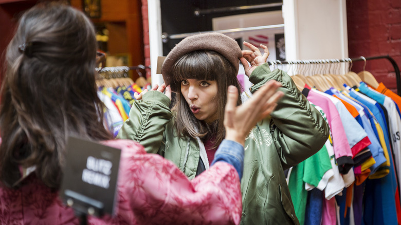 Woman trying on hat in store