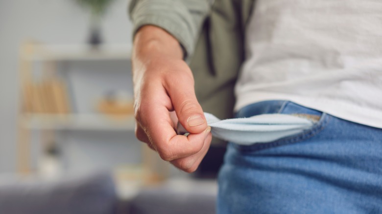 Woman in blue jeans turning her pockets inside out