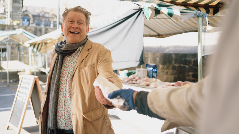 Man purchasing food from a vendor on the street