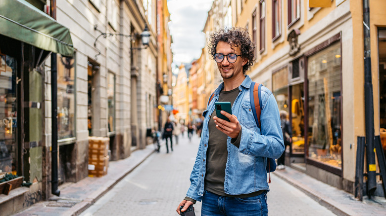 man browsing phone in european city