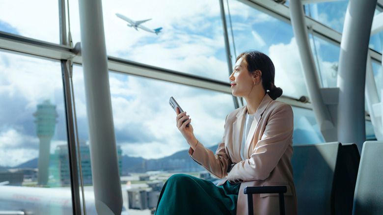 woman sitting in airport departures terminal
