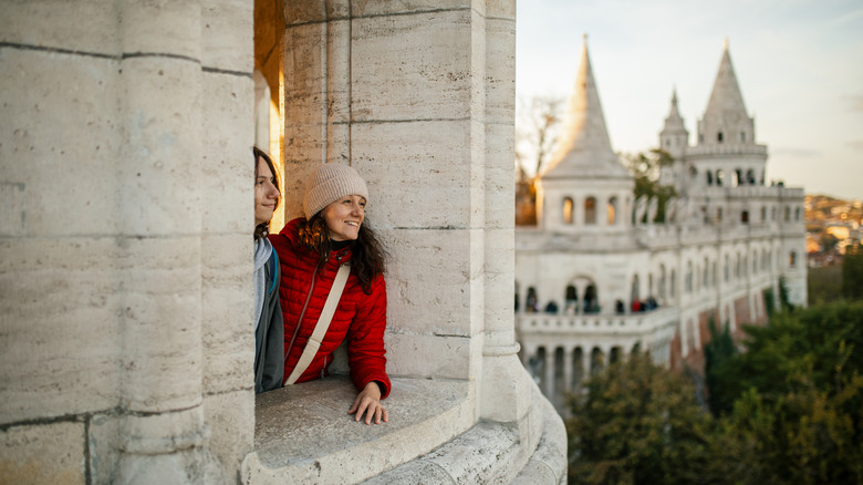 Mother and son at Fisherman's bastion in Budapest, enjoying the view, looking happy and relaxed.