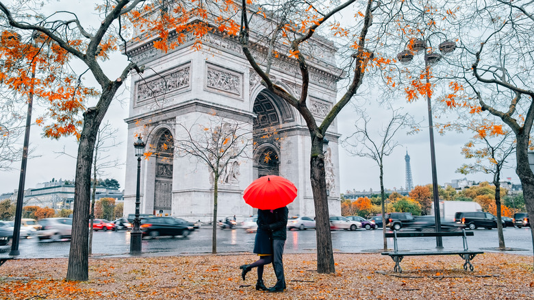 Couple under umbrella at rain in Paris.