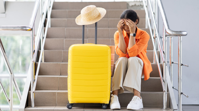 A young woman in an airport looking frustrated.