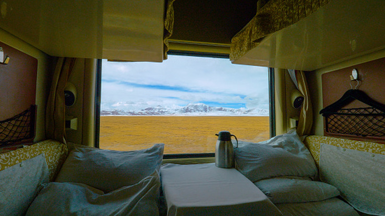 sleeper cabin on a train with scenic mountains visible through the window
