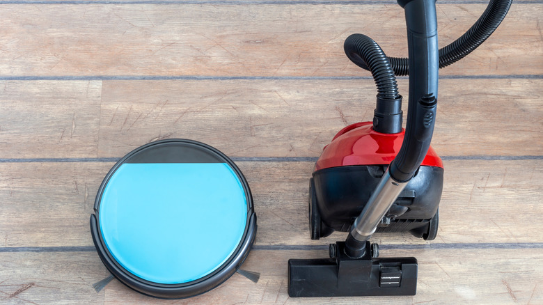 picture of robot vacuum beside a regular vacuum