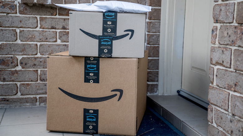Picture of two stacked Amazon boxes and a white envelop by a door
