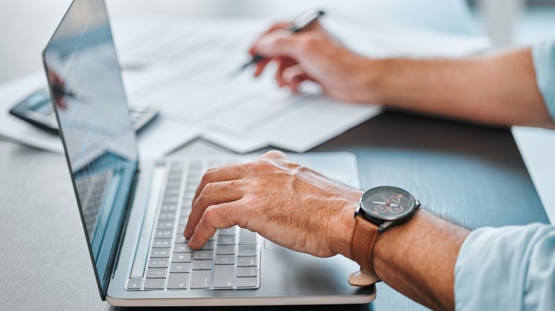 A person using their laptop on a desk