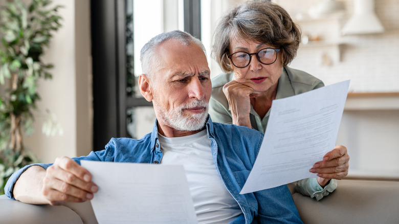 Two seniors reading documents