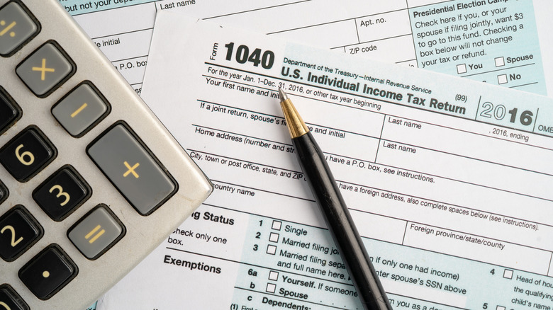 A Form 1040, U.S. Individual Income Tax Return on a table with a pen and calculator.