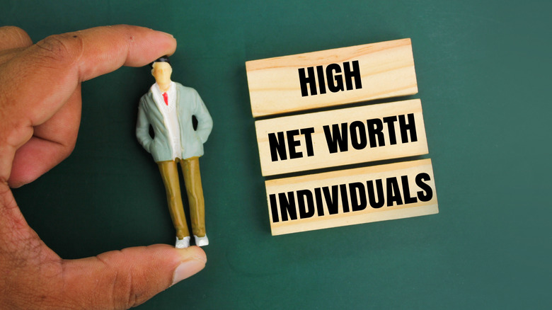 high net worth individual in blocks next to person figurine