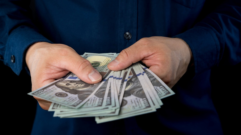Close up of businessman counts money in hands