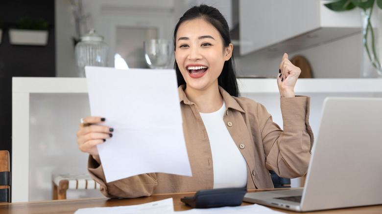 Woman looking at a document with excitement