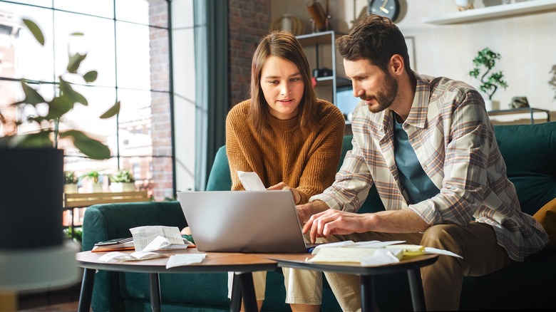 Couple smiling, looking at computer