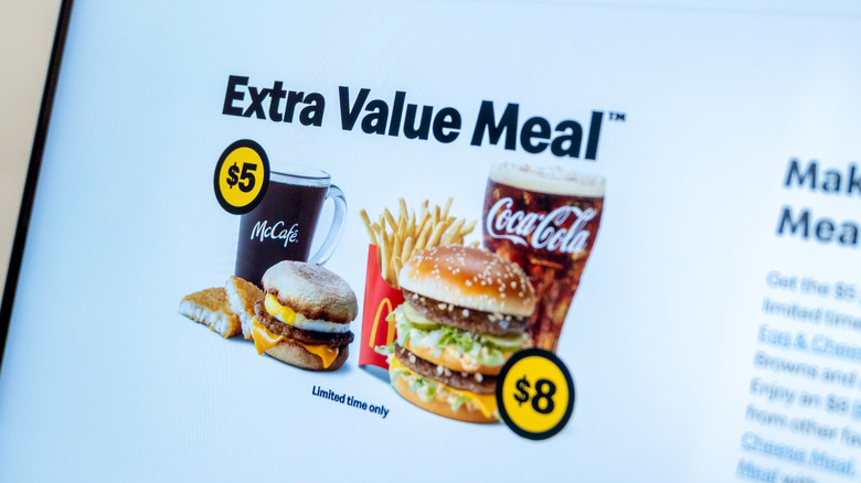 Laptop displaying McDonald's website featuring Extra Value Meal deals, including McCafe coffee, Big Mac, and Coca Cola.