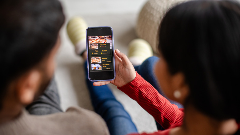 Couple using smartphone app to order food