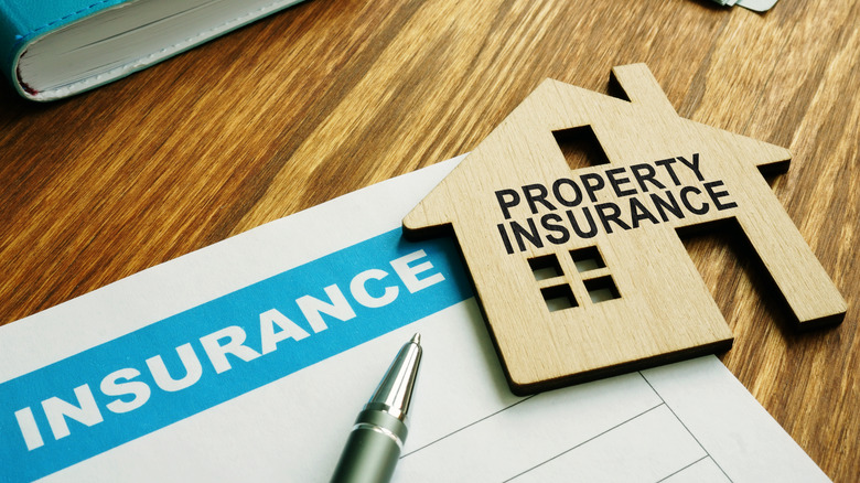 Property insurance stamp on a model wooden home.