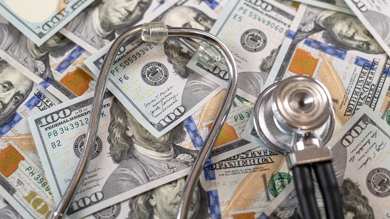 A stethoscope on dollar banknotes as premium medical insurance concept.