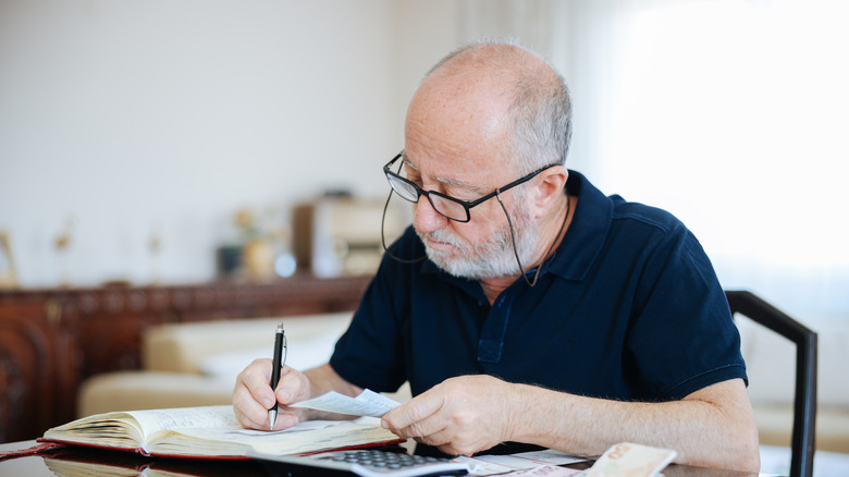 Senior man checking calculating personal finance at home.