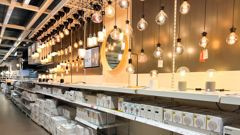 Shelves in an IKEA store showcasing home lighting equipment, including bulbs, light fixtures, and a variety of options.