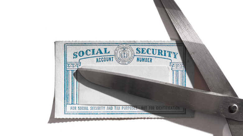 Pair of scissors about to cut Social Security card